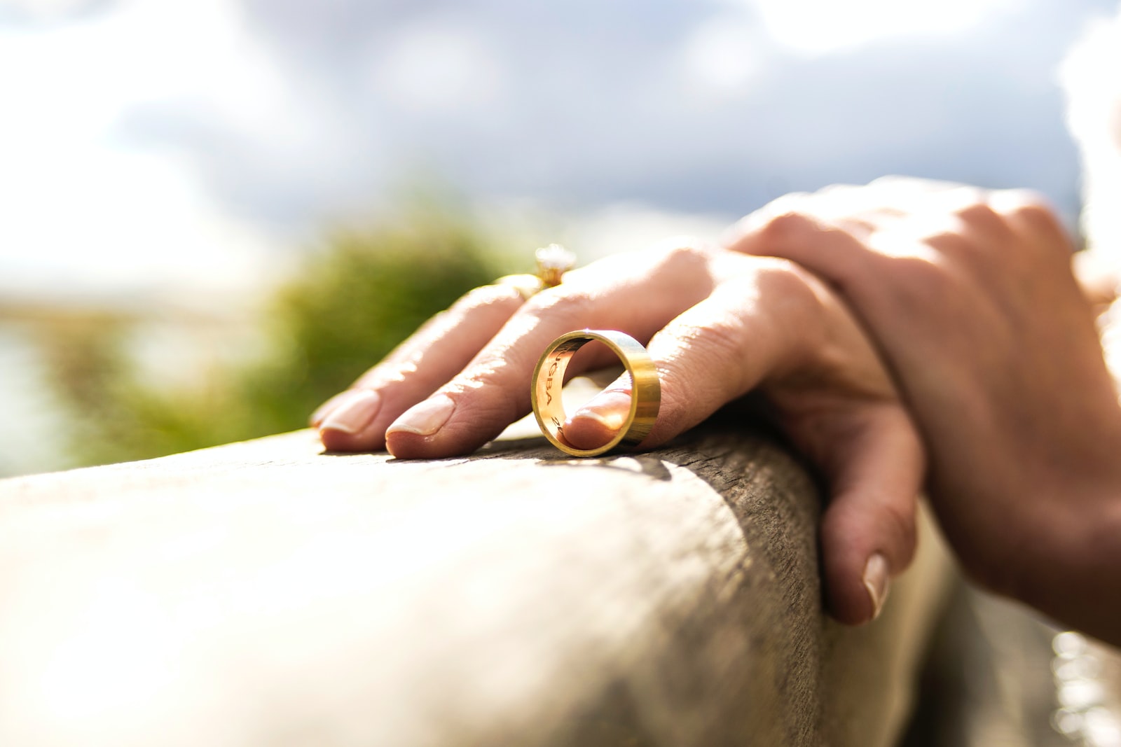 person holding gold wedding band