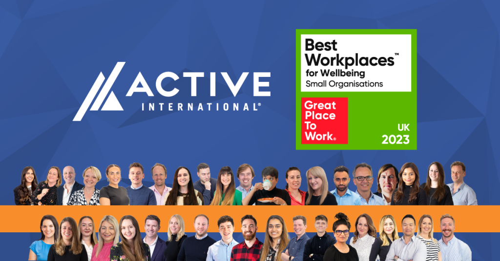 Group photo of Active International employees with the company's logo and awards for "Best Workplaces for Wellbeing" and "Great Place to Work UK 2023" against a blue background, highlighting our commitment to employee health and safety.