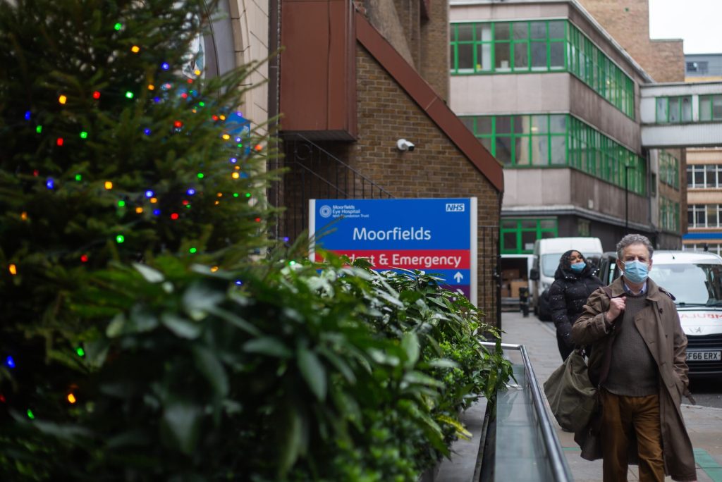 a man wearing a face mask walking down a street