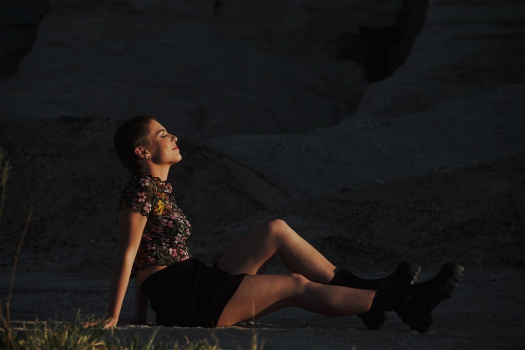 woman in black and white floral dress sitting on rock