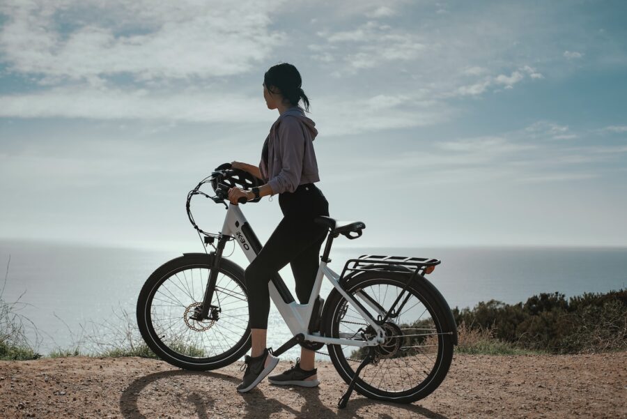 man in white shirt and black shorts riding black bicycle during daytime