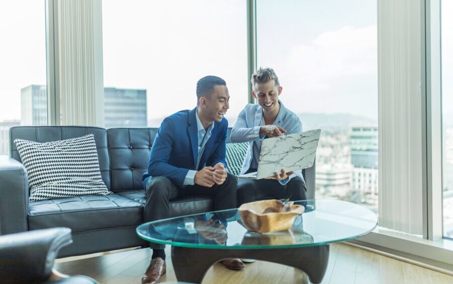 two men in suit sitting on sofa