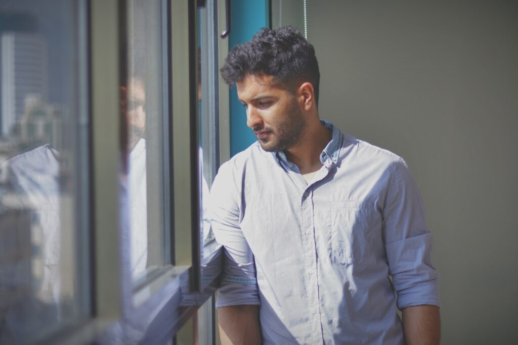 a man looking out the window of a building