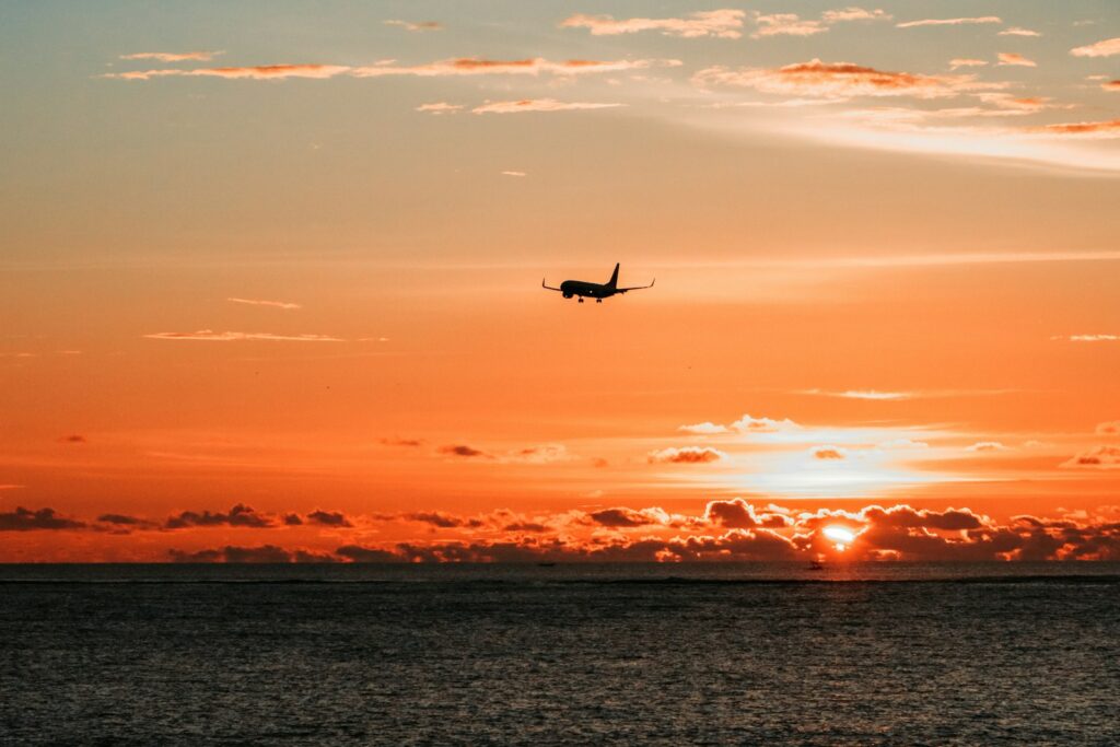 airplane on mid air above body of water