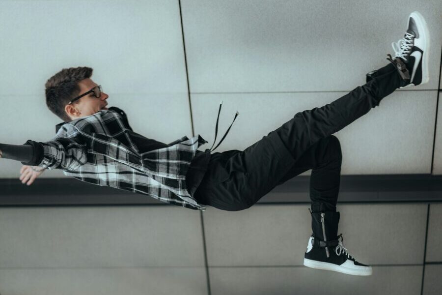 man in black and white plaid dress shirt and black pants lying on floor