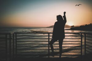 Silhouette of woman with hand held high