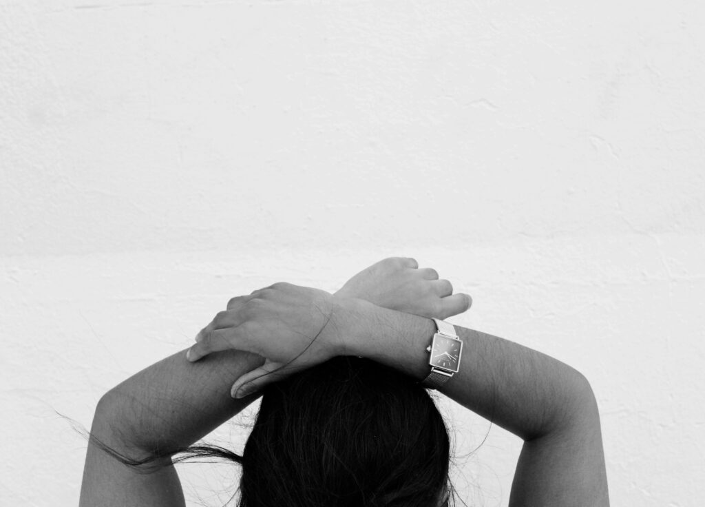 Woman crossing her arms above her head