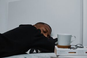 Man asleep on desk gen z