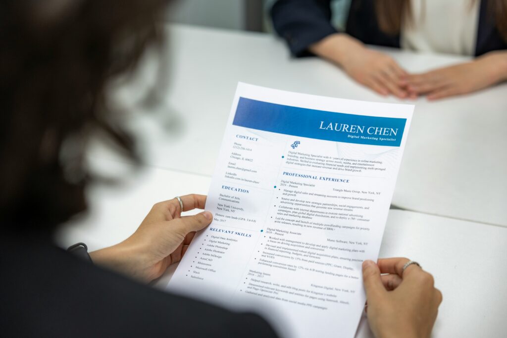 A person is commonly seen holding and reviewing a resume during a meeting.