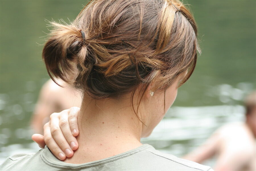 A woman massages her sore neck.