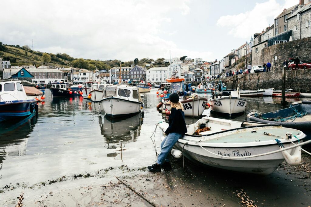 Charming Cornish harbor scene with boats and classic seaside architecture in England, United Kingdom.