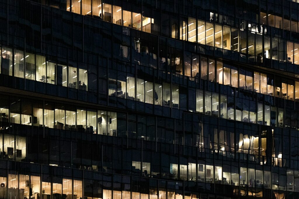 An office building with the lights on at night.