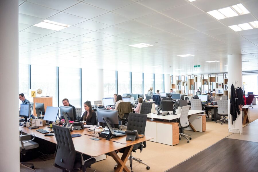 Wide view of an office with desks and charis.