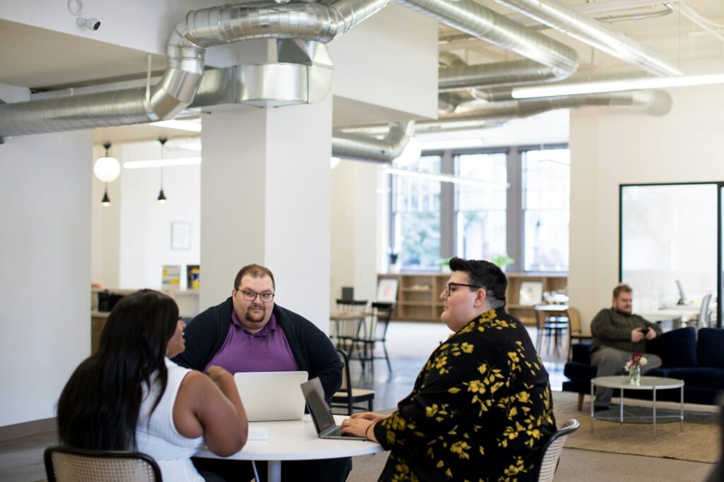 Overweight people sitting at an office table.