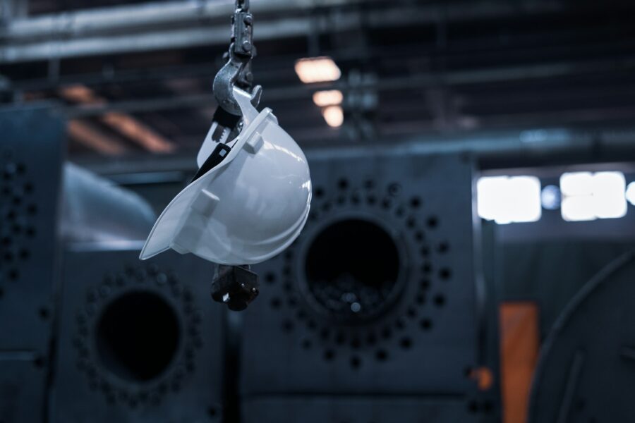 A safety hat hangs from a chain.