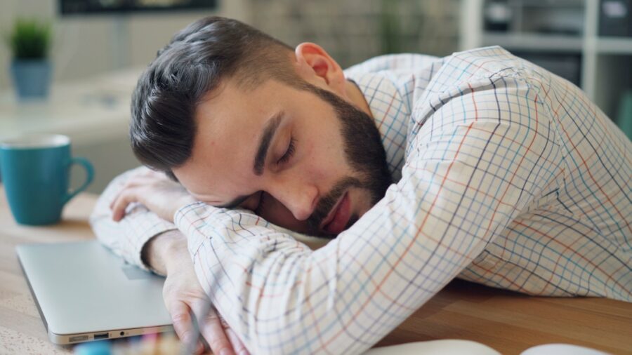 A man laying his head on his laptop.