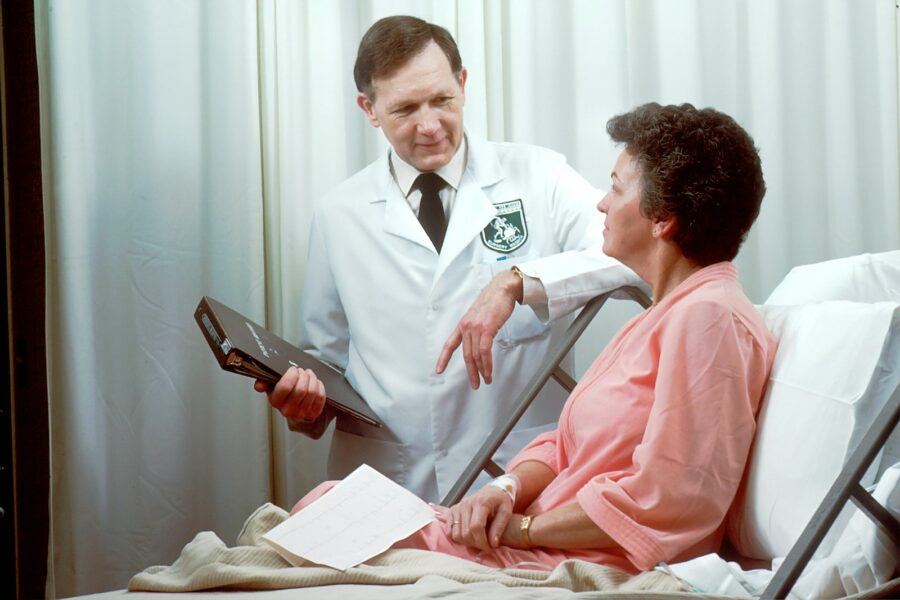 A woman is examined by a doctor in a hospital setting.