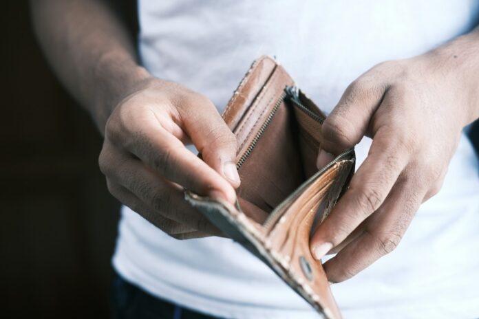 A person holding an empty wallet.