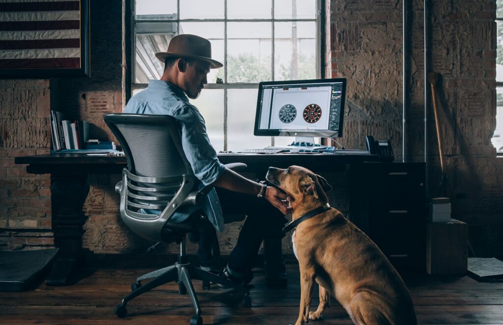 A man in an office with his dog.