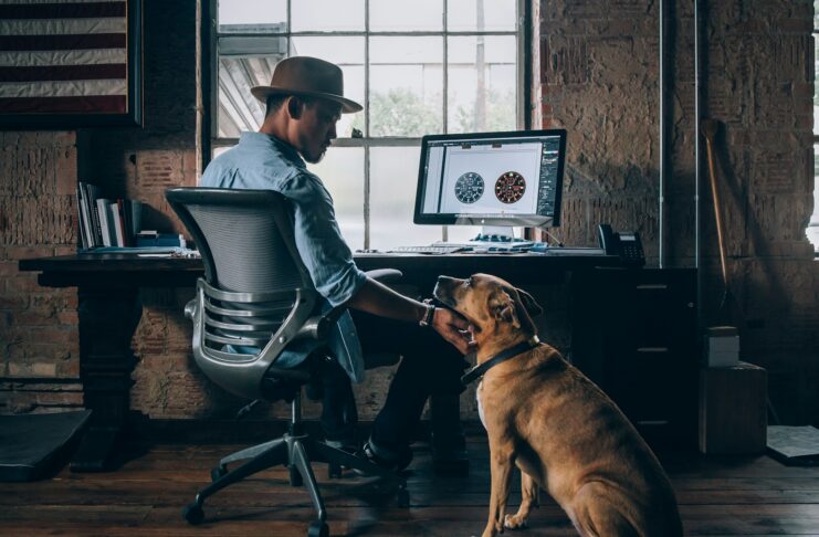 A man in an office with his dog.