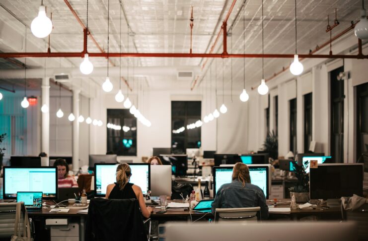 People working at computers in an open-plan office.