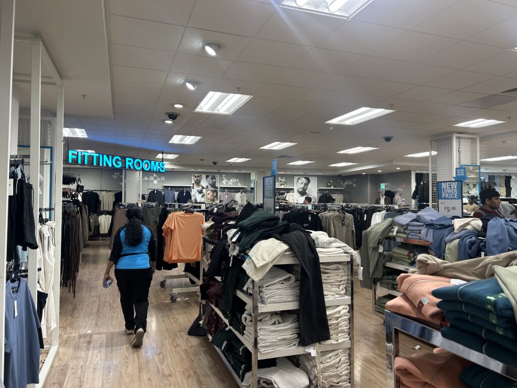 A member of staff walks in a clothing store.