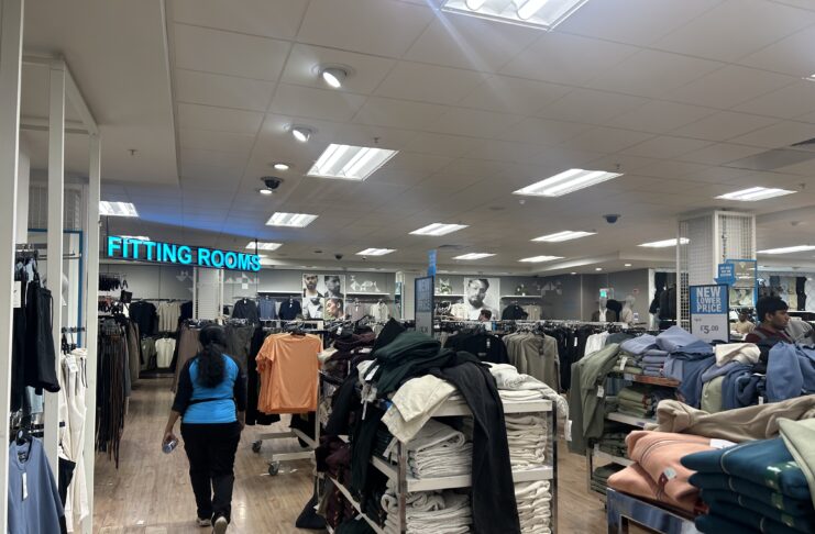 A member of staff walks in a clothing store.