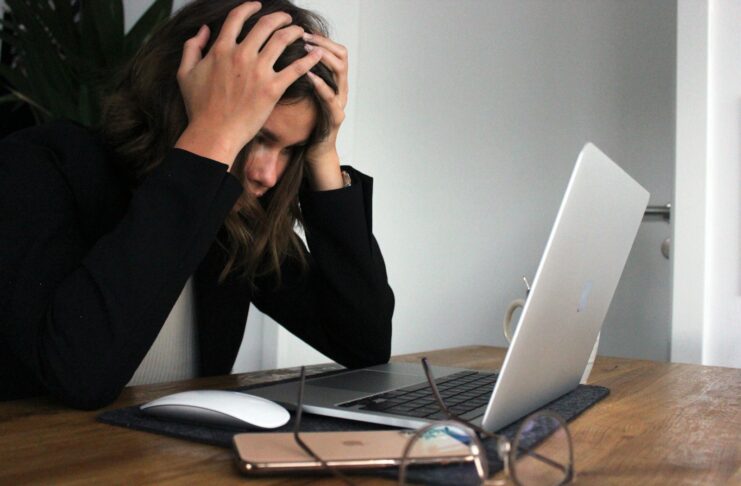 A stressed woman sitting in front of a laptop computer