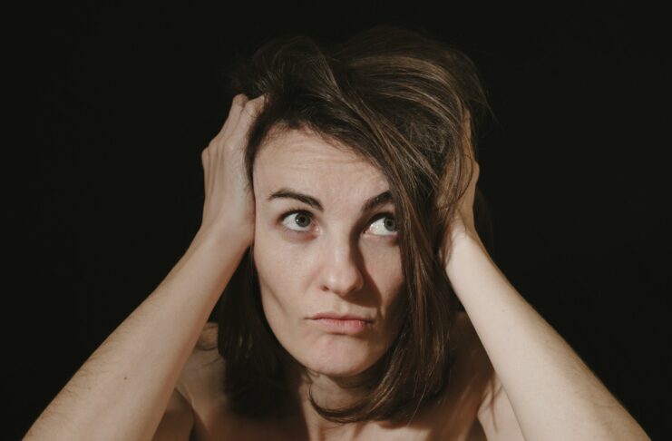 A woman holding her head in her hands.