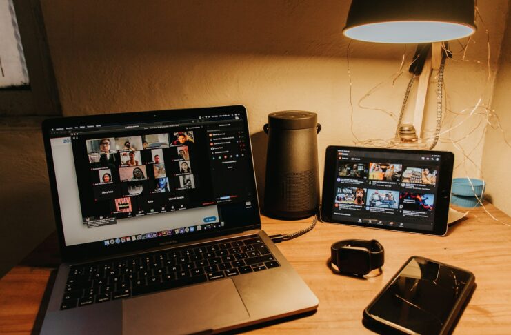 A laptop, tablet computer and mobile phone on a desk.