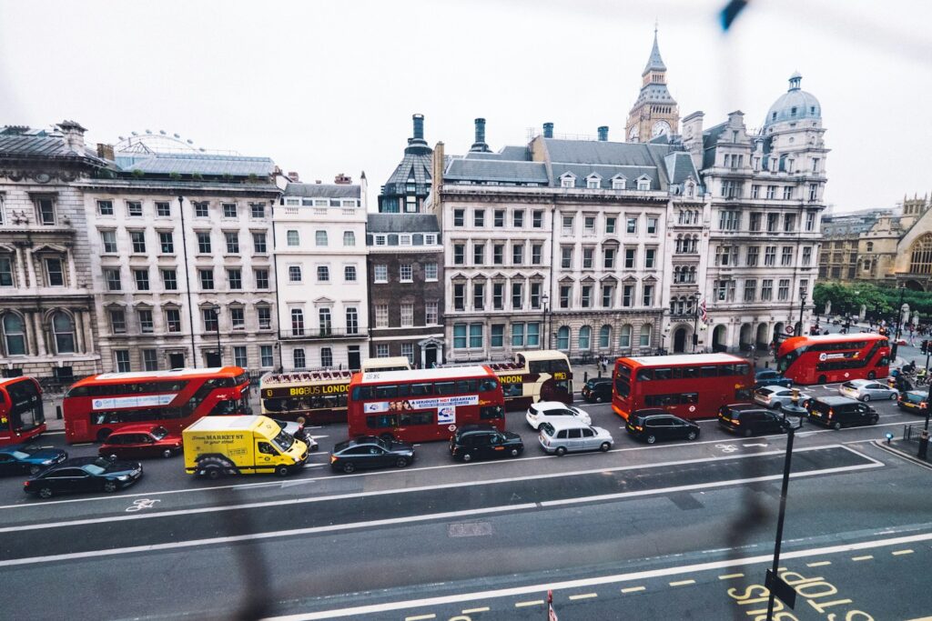 Buses and cars on a British street.