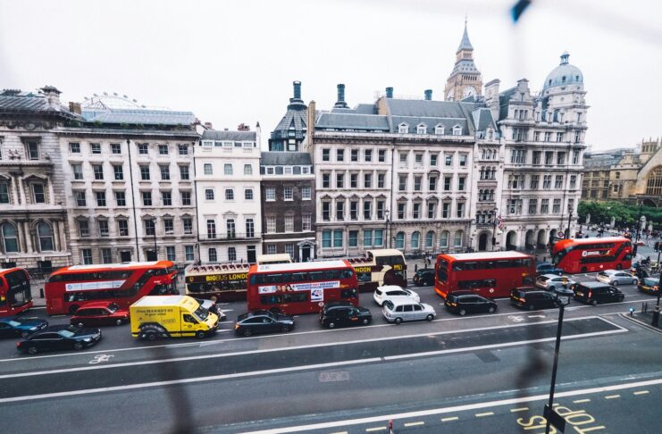 Buses and cars on a British street.