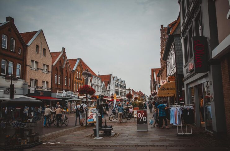 A bustling urban street with shops, people, and bicycles in a lively marketplace atmosphere.