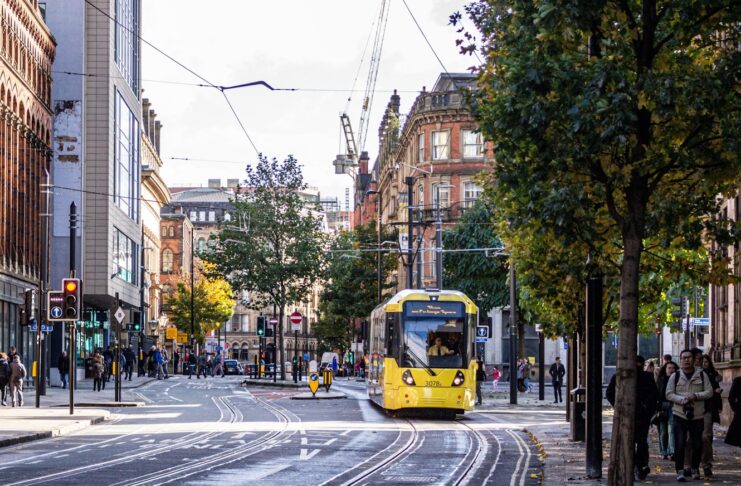 A Manchester street with people and a tram.