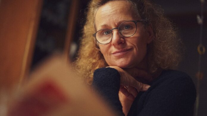 An older woman wearing glasses looking at the camera.