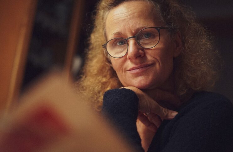 An older woman wearing glasses looking at the camera.