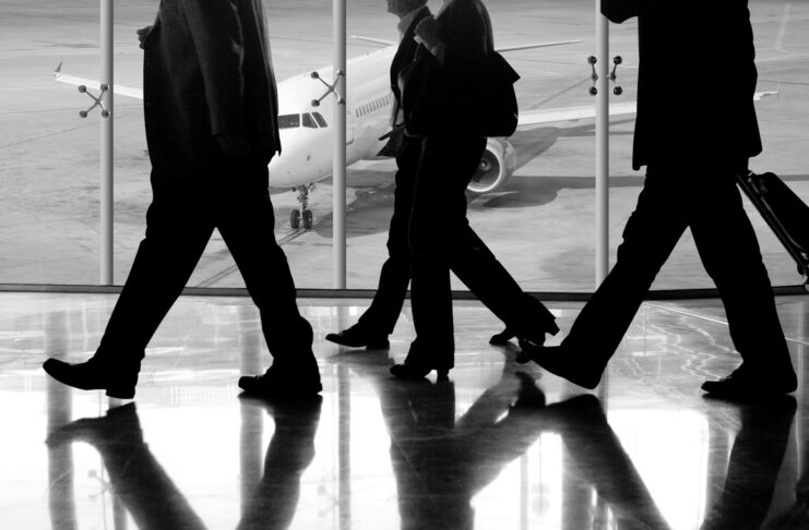 Businesspeople walk in an airport.