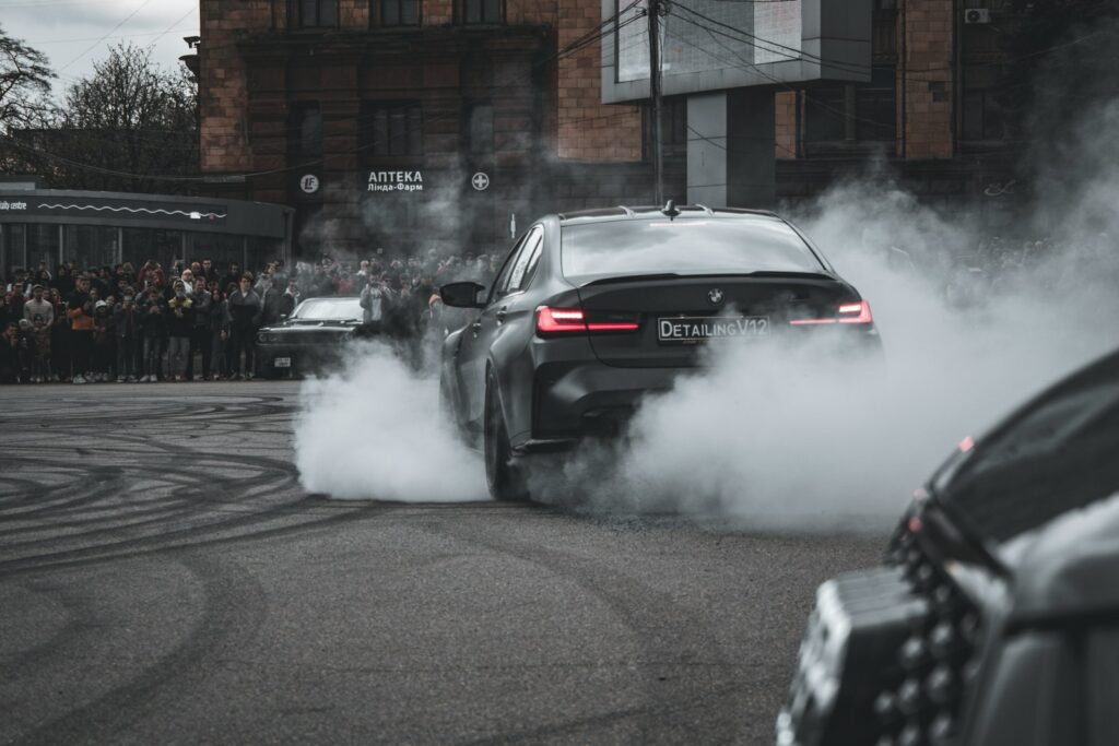 A car drives along a street while emitting pollutants.