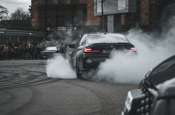 A car drives along a street while emitting pollutants.