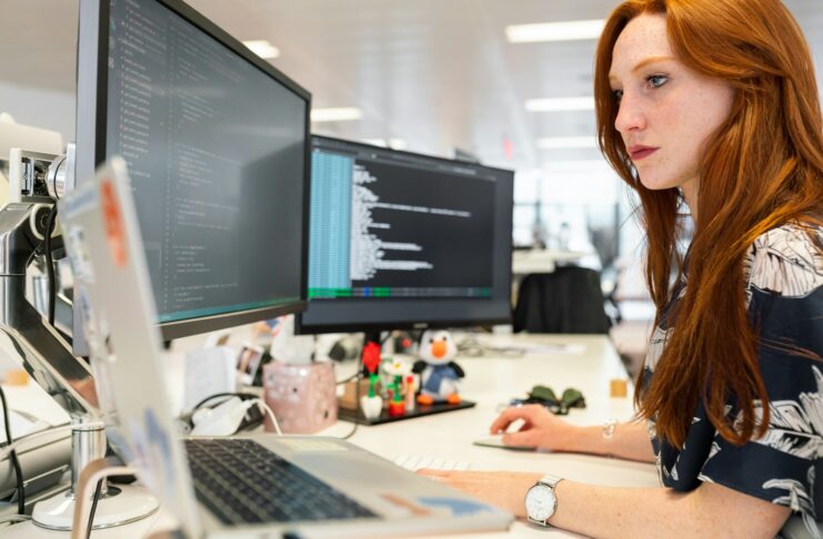 A woman looking at computer screens.