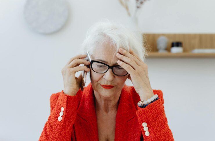 A businesswoman on the phone while looking stressed.
