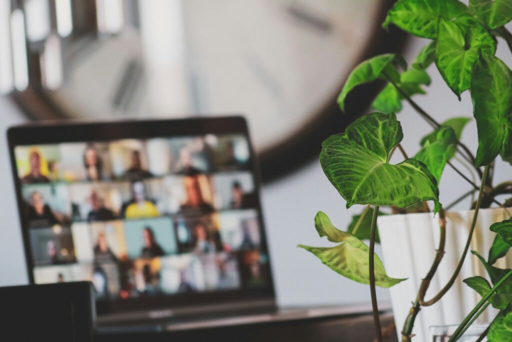 A laptop in a home setting showing an online meeting in progress.