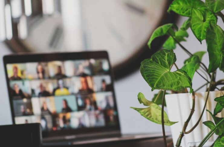 A laptop in a home setting showing an online meeting in progress.