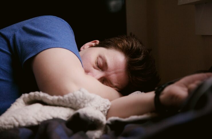 A person lies on a bed.