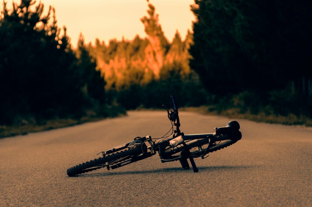 A bike laying on its side on the side of the road.