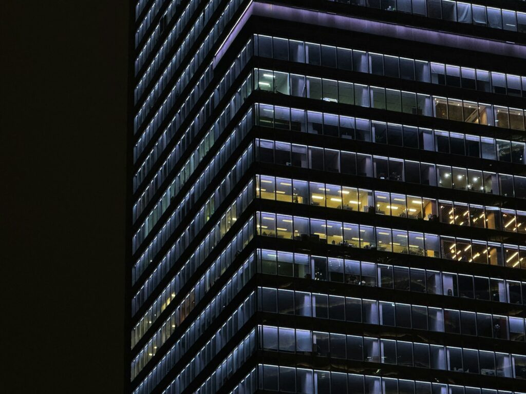 Some offices with lights still on in a skyscraper at night.
