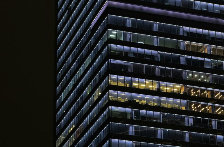 Some offices with lights still on in a skyscraper at night.