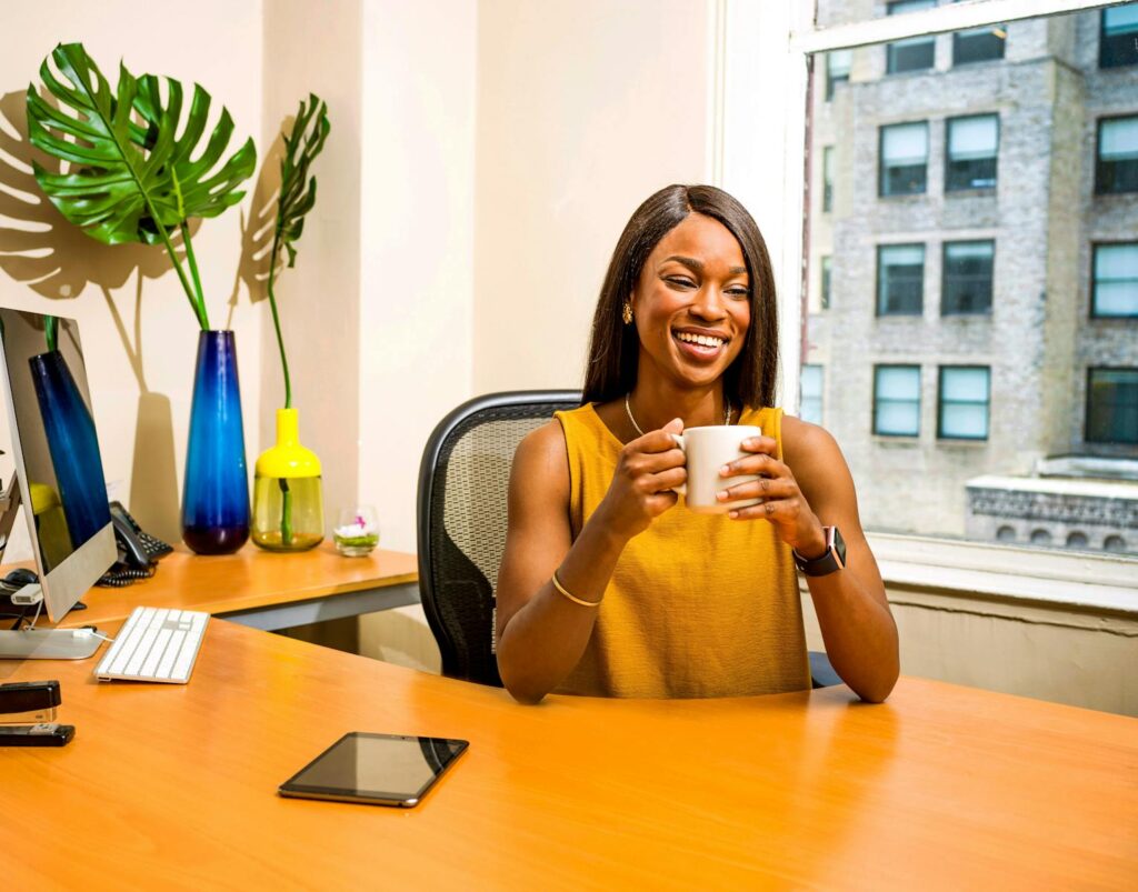 A smiling woman at her desk in an office.