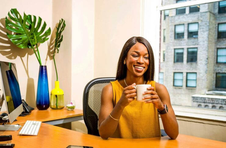 A smiling woman at her desk in an office.