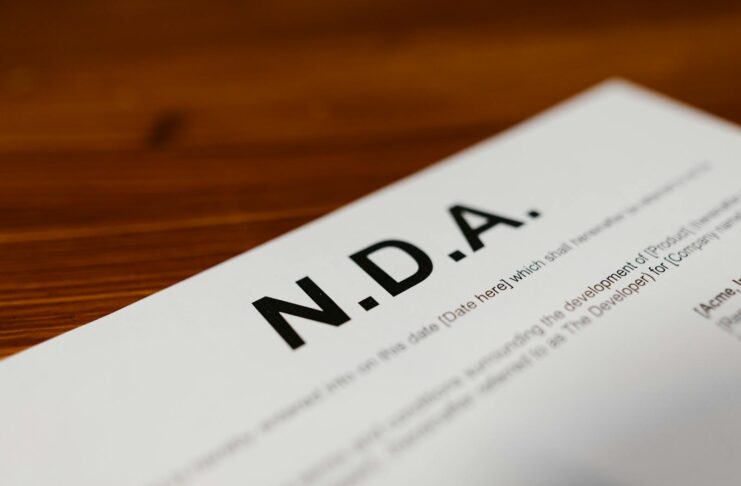 Focused close-up of an NDA document on a wooden desk, highlighting contract details.